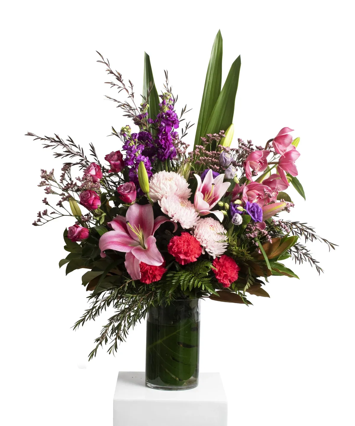 Tall pink and purple arrangement in a large glass vase
